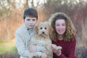Brother and sister holding their family dog