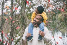 Father with his son standing by an autumn tree
