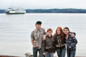 Kids posing while ferry boat arrives to the dock in West Seattle.